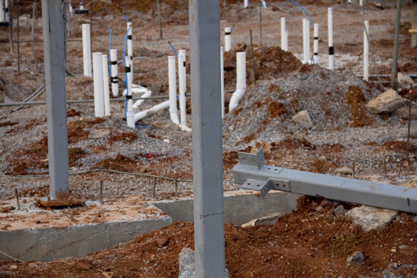 Foundation construction underway at the ICM building site in late 2011, with support posts, plumbing pipes, and poured concrete footings
